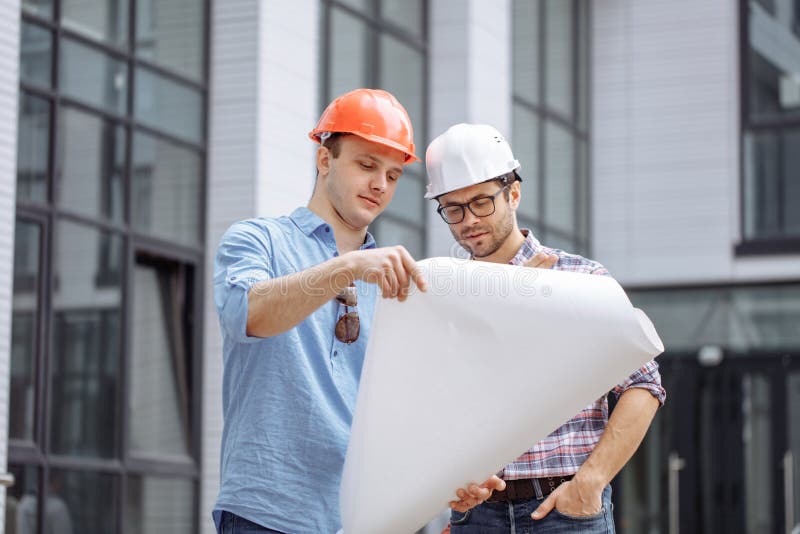 Dos ingenieros ambiciosos se están convirtiendo poseen ideas de crear el rascacielos fotografía de archivo Dos ingenieros ambiciosos se están convirtiendo poseen ideas de crear el rascacielos fotografía de archivo