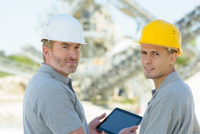 Dos ingenieros revisando tableta al aire libre imagenes de archivo