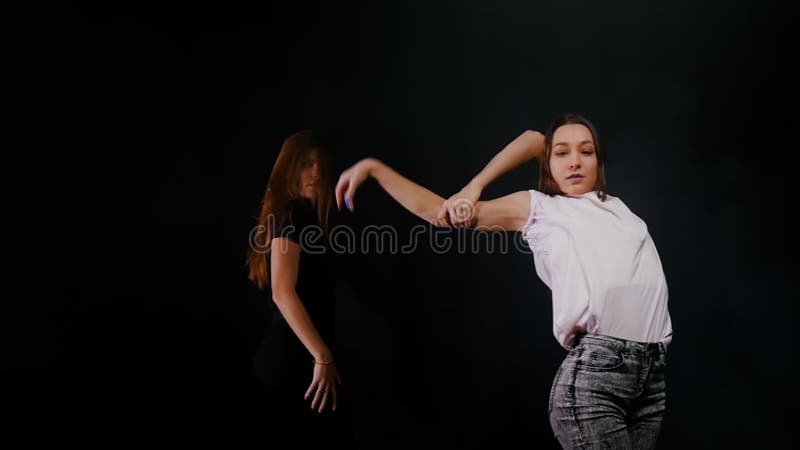 Dos jóvenes manos bailarinas calentándose y posando en el estudio