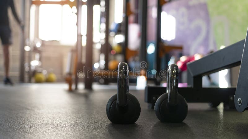 Dos kettlebells negros en el piso del gimnasio del deporte foto de archivo Dos kettlebells negros en el piso del gimnasio del deporte foto de archivo