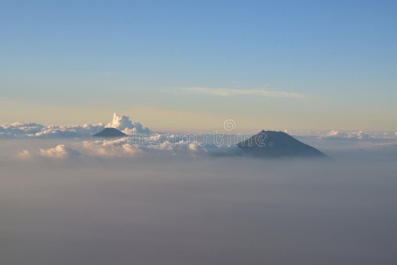 The silky surface beautiful clouds sometimes gave the impression that smoke is coming out from the mountain. These mountains are part of the 11 volcanoes in Central Java and the highest one is possibly mount merapi. If you observe properly, there seem to be a crater at the peak. This image is taken after the flight took off from Adisutjipto International Airport. The silky surface beautiful clouds sometimes gave the impression that smoke is coming out from the mountain. These mountains are part of the 11 volcanoes in Central Java and the highest one is possibly mount merapi. If you observe properly, there seem to be a crater at the peak. This image is taken after the flight took off from Adisutjipto International Airport.