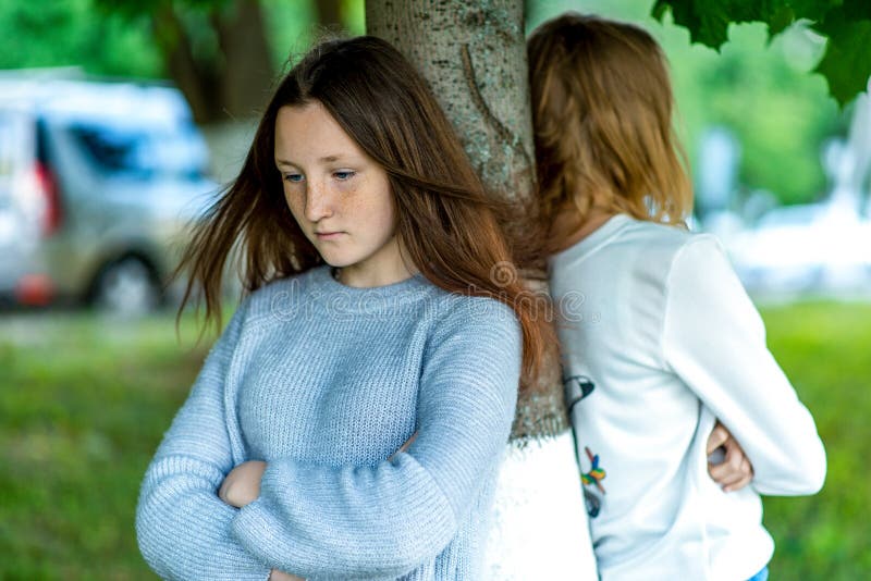 Dos muchachas en verano en el parque El concepto de amigos en una pelea, adolescente de la escuela del problema Emociones del con imagen de archivo Dos muchachas en verano en el parque El concepto de amigos en una pelea, adolescente de la escuela del problema Emociones del con imagen de archivo