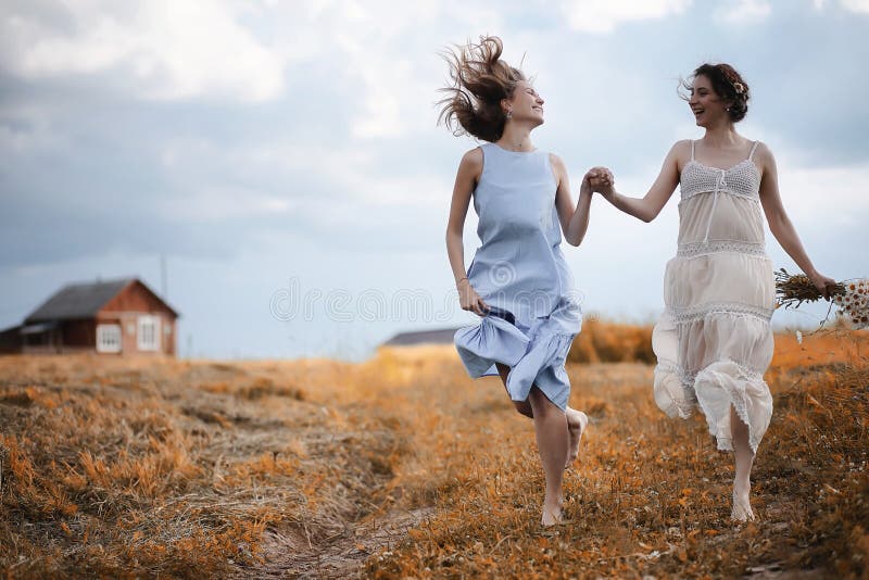 Dos muchachas en vestidos en campo del otoño imagen de archivo libre de regalías
