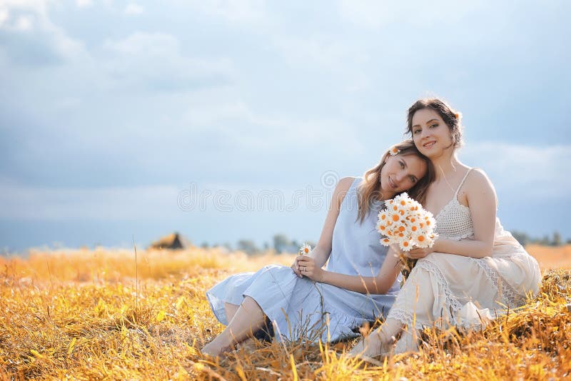 Dos muchachas en vestidos en campo del otoño imagen de archivo