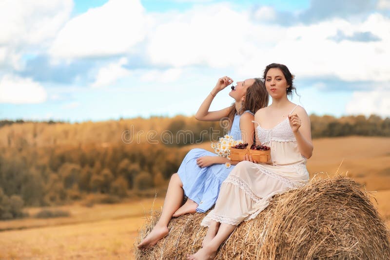 Dos muchachas en vestidos en campo del otoño imagen de archivo libre de regalías