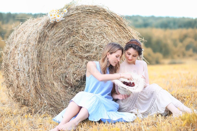 Dos muchachas en vestidos en campo del otoño foto de archivo
