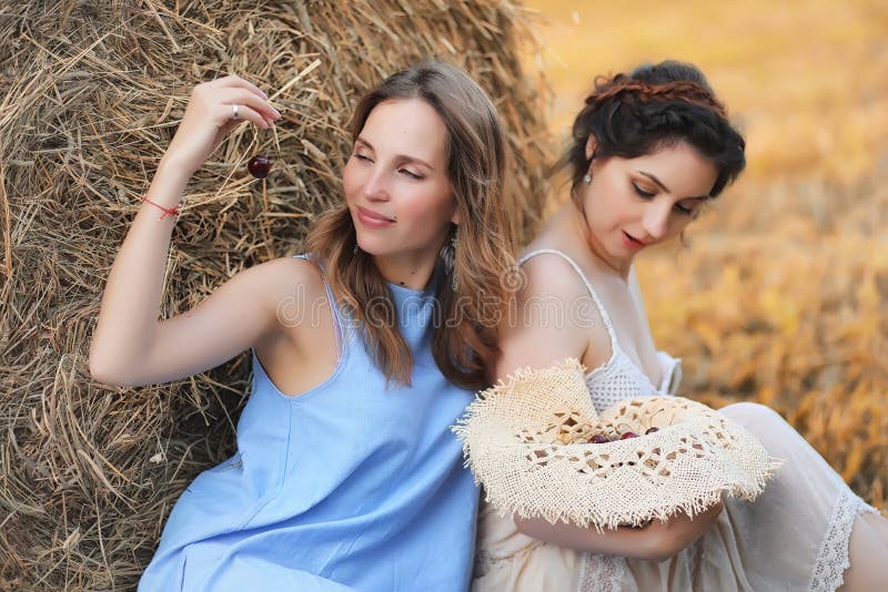 Dos muchachas en vestidos en campo del otoño foto de archivo libre de regalías