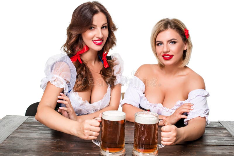 Dos muchachas rubias y morenas hermosas del stein más oktoberfest de la cerveza fotografía de archivo libre de regalías Dos muchachas rubias y morenas hermosas del stein más oktoberfest de la cerveza fotografía de archivo libre de regalías