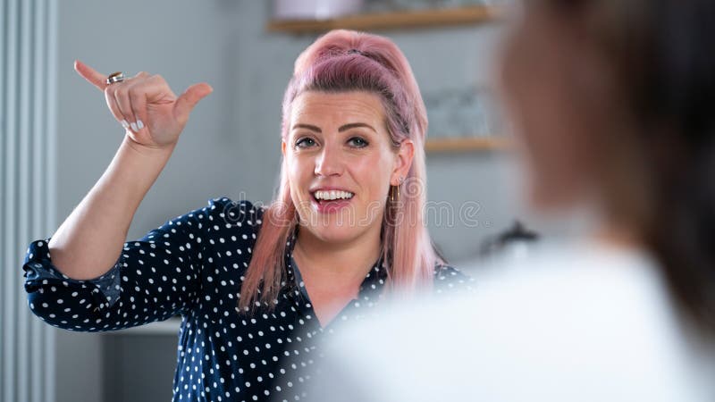 Two Women Have Conversation At Home Using Sign Language. Two Women Have Conversation At Home Using Sign Language