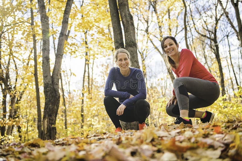 Dos mujeres corriendo trotando en la naturaleza otoñal imagen de archivo