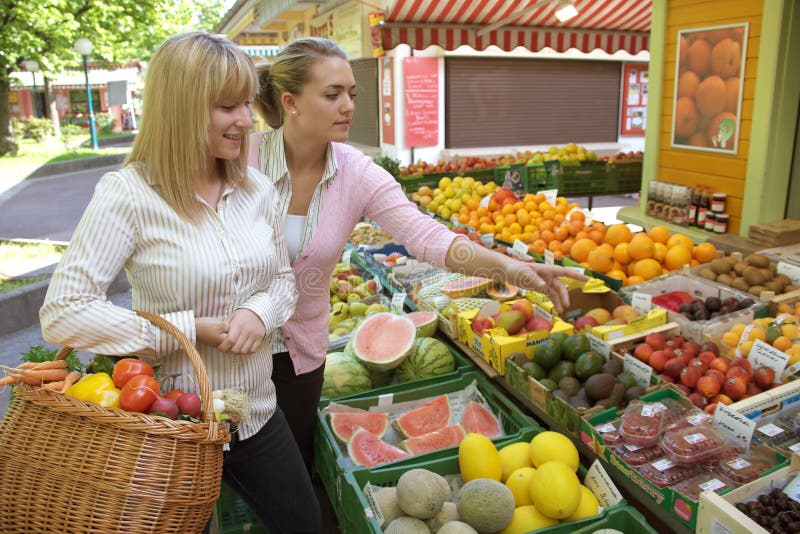 Dos mujeres en la mercado de la fruta imagenes de archivo Dos mujeres en la mercado de la fruta imagenes de archivo