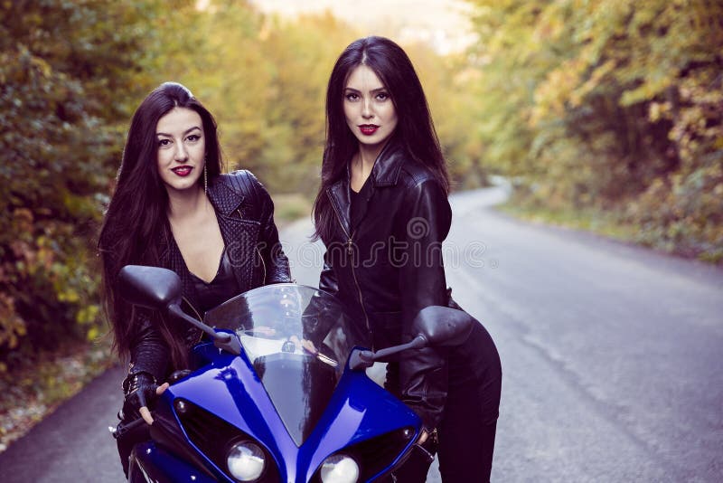 Dos mujeres hermosas apasionadas sobre las motocicletas fotos de archivo libres de regalías Dos mujeres hermosas apasionadas sobre las motocicletas fotos de archivo libres de regalías
