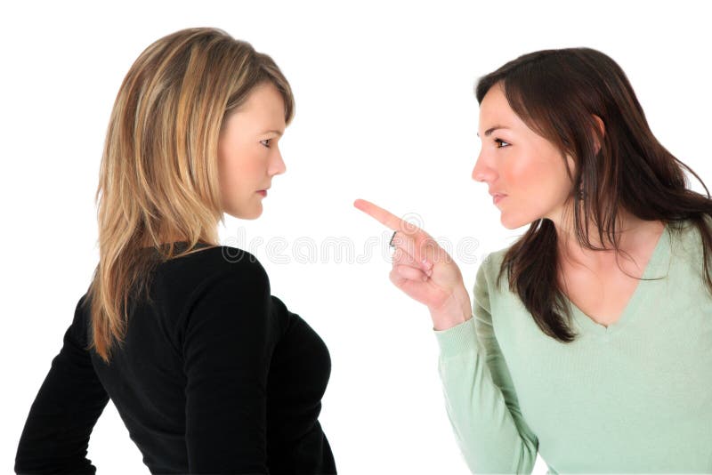 Neatly dressed brunette pointing accusing finger at a blond woman. Neatly dressed brunette pointing accusing finger at a blond woman