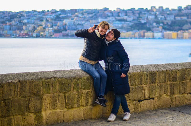 Dos mujeres sonrientes jovenes en el fondo de la ciudad en la puesta del sol ‹Azul del †del ‹del †del mar en el fondo imagenes de archivo Dos mujeres sonrientes jovenes en el fondo de la ciudad en la puesta del sol ‹Azul del †del ‹del †del mar en el fondo imagenes de archivo