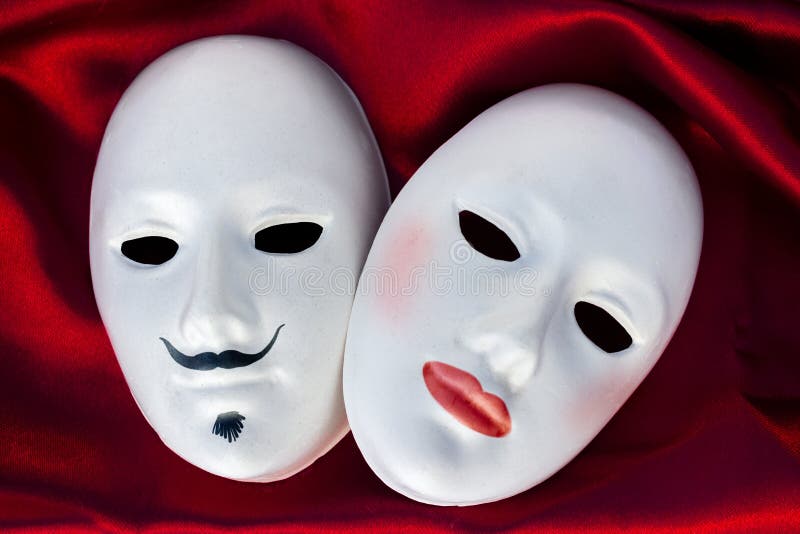 Female and male plaster masks on silk fabric, close up. Female and male plaster masks on silk fabric, close up