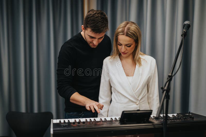Dos músicos practicando la música de teclado en un estudio moderno imagen de archivo libre de regalías