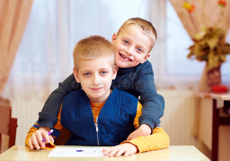Dos niños lindos, amigos en la escuela de la rehabilitación para los niños con necesidades especiales imagen de archivo libre de regalías Dos niños lindos, amigos en la escuela de la rehabilitación para los niños con necesidades especiales imagen de archivo libre de regalías