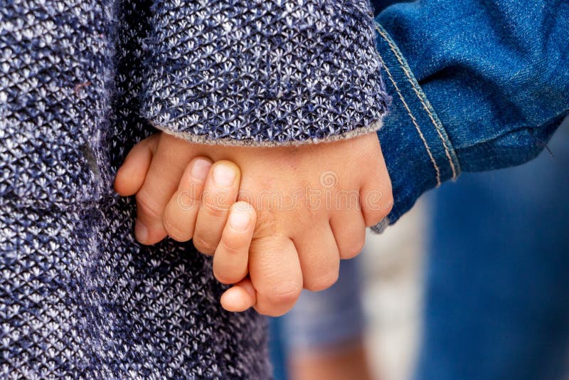 Dos niños pequeños se toman de la mano. Una chica sostiene a su hermano a mano. fotos de archivo libres de regalías