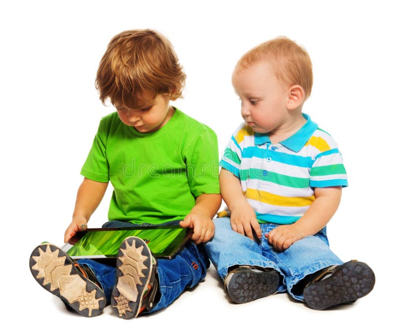 Dos niños que juegan la tablilla imagen de archivo libre de regalías