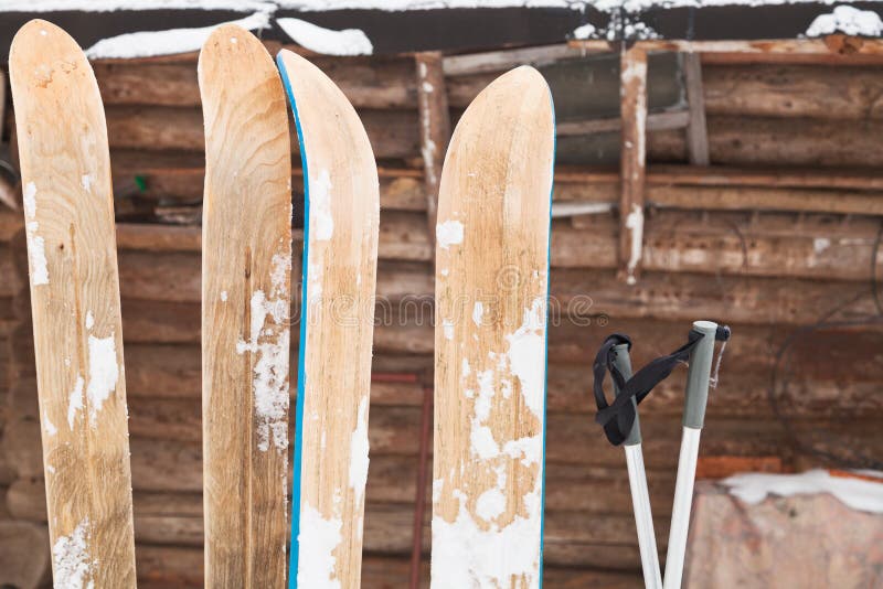 Two pairs of wide skis and log house wall in winter day. Two pairs of wide skis and log house wall in winter day