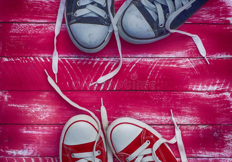 Two pairs of sneakers in bright pink vintage background, toning. Two pairs of sneakers in bright pink vintage background, toning