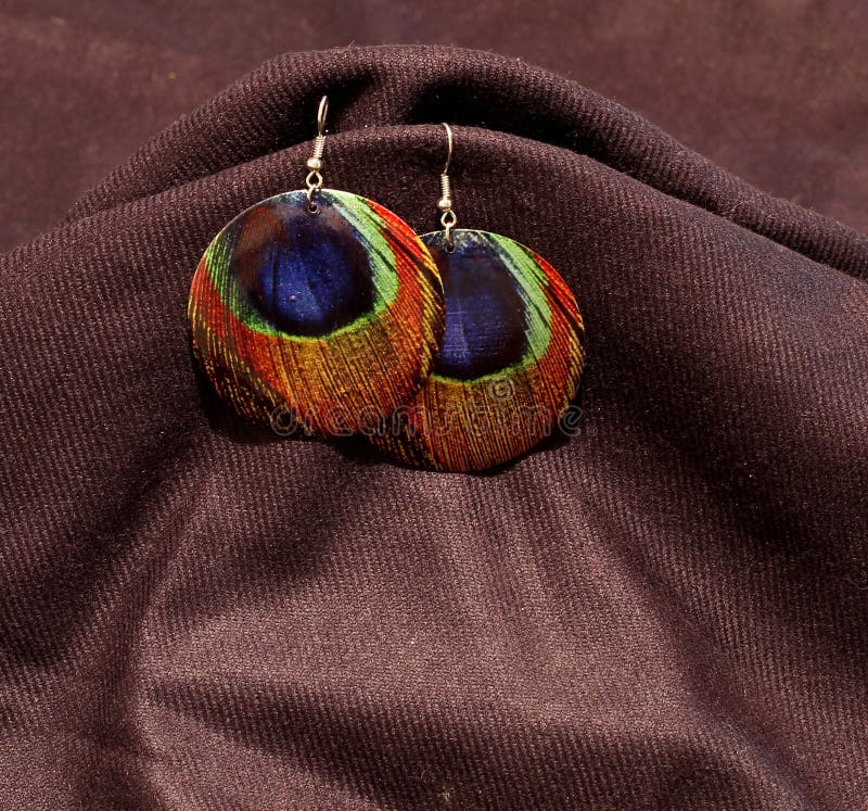 Dos pendientes con diseño de la pluma del pavo real del multicolor fotografía de archivo libre de regalías Dos pendientes con diseño de la pluma del pavo real del multicolor fotografía de archivo libre de regalías