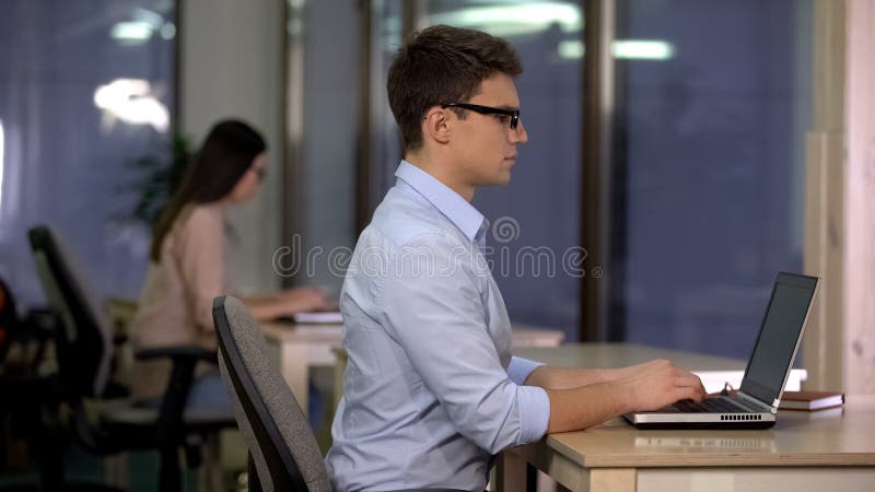 Dos personas que trabajan en el ordenador portátil en la oficina grande, soporte técnico, centro de servicio foto de archivo Dos personas que trabajan en el ordenador portátil en la oficina grande, soporte técnico, centro de servicio foto de archivo