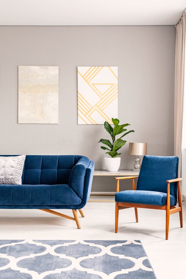 Dos pinturas del arte moderno que cuelgan en la pared en foto real del interior brillante del salón con el sofá y la butaca azule fotos de archivo libres de regalías Dos pinturas del arte moderno que cuelgan en la pared en foto real del interior brillante del salón con el sofá y la butaca azule fotos de archivo libres de regalías