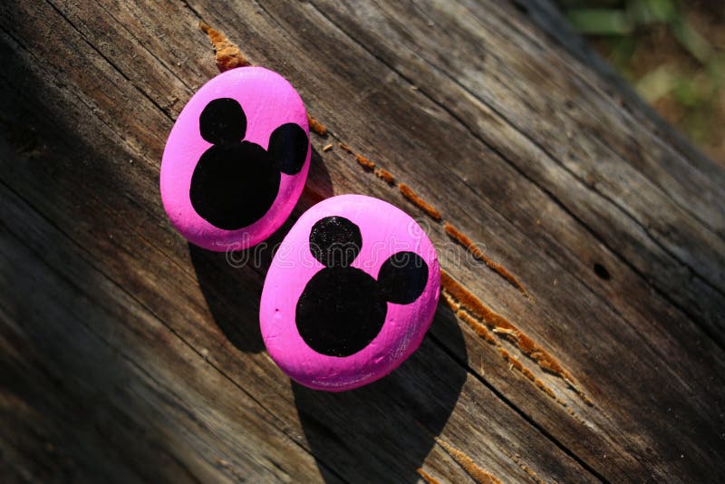 Dos rocas pintadas rosadas con las cabezas negras de Mickey Mouse fotos de archivo Dos rocas pintadas rosadas con las cabezas negras de Mickey Mouse fotos de archivo