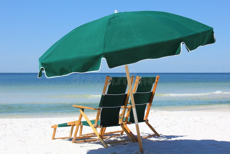 Dos sillas y paraguas en la playa blanca de la arena
