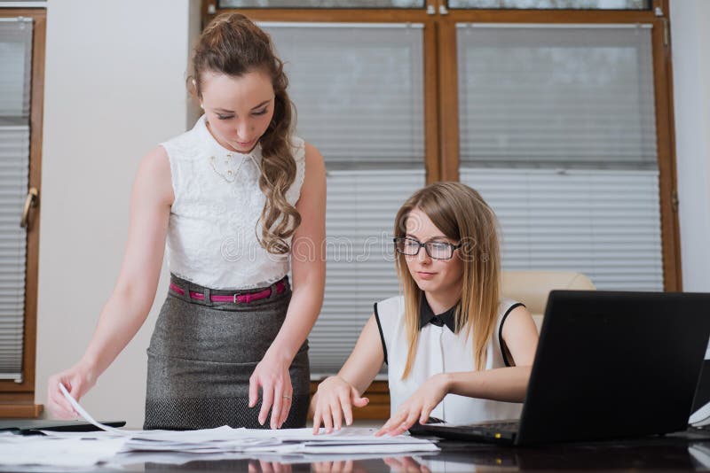 Dos socios comerciales de las mujeres miran en estados financieros, estadísticas y documentos fotos de archivo libres de regalías Dos socios comerciales de las mujeres miran en estados financieros, estadísticas y documentos fotos de archivo libres de regalías