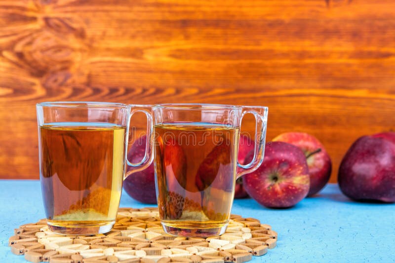 Dos vidrios de zumo de manzana y de manzanas rojas en fondo de madera imagenes de archivo Dos vidrios de zumo de manzana y de manzanas rojas en fondo de madera imagenes de archivo