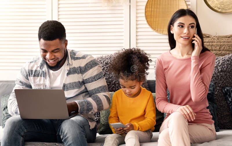 Dotter till bärbara datorer spelar på smartphone-mamma pratar på telefon royaltyfri foto