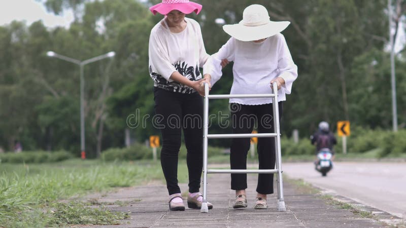 Dottern tar omsorg den äldre kvinnan som går på gatan