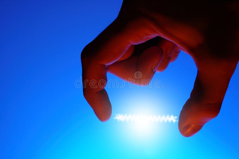 Silhouette of hand with energy glowing between fingers - blue background. Silhouette of hand with energy glowing between fingers - blue background