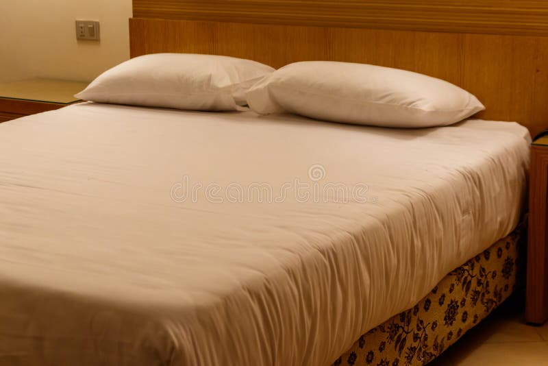 Double Bed with Two Pillows in Bedroom in Soft Lights Stock Image