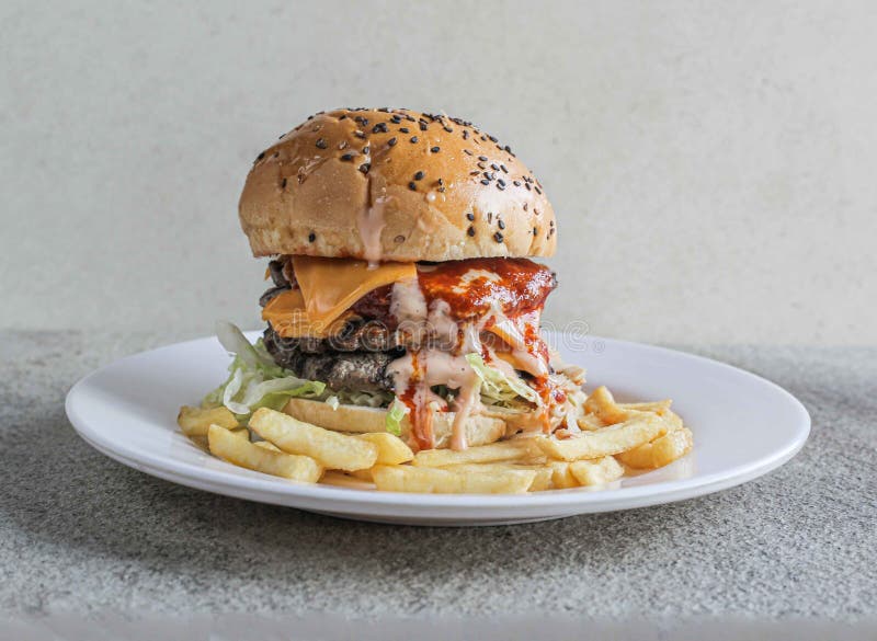 Double beef cheese burger with fries served in a dish isolated on grey background side view of fast food.