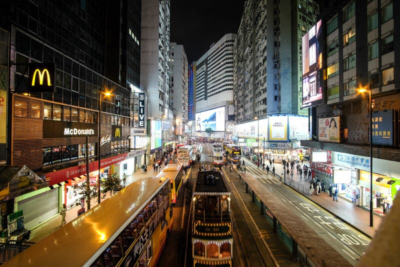 Double decker buses drive on the road of Causeway Bay on a rainy evening royalty free stock photography