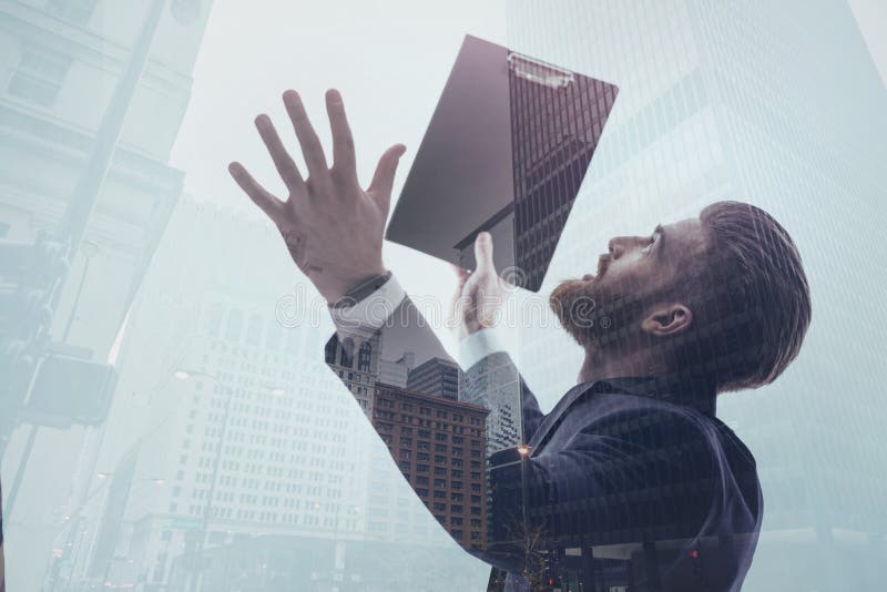 Longing for success. Inspired male manager is looking at urban skyscrapers and gesturing with excitement. He is holding folder with documents. Double exposure. Longing for success. Inspired male manager is looking at urban skyscrapers and gesturing with excitement. He is holding folder with documents. Double exposure