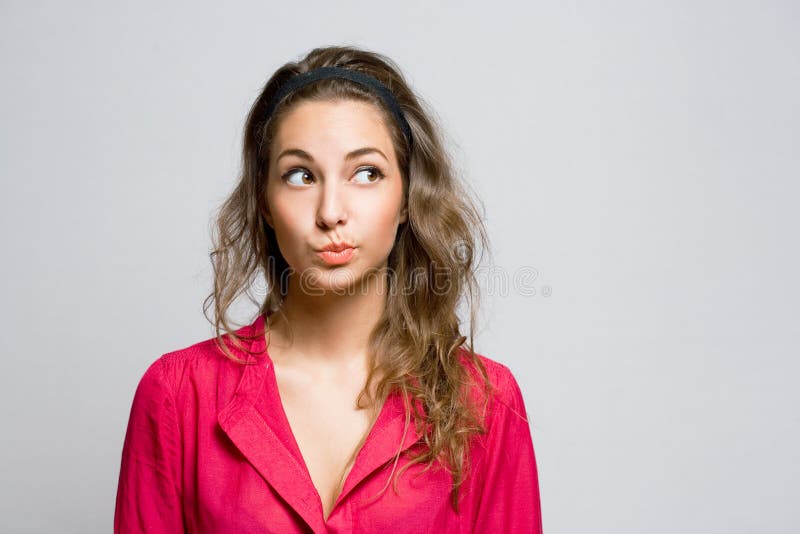 Doubtfu young brunette woman. stock photo