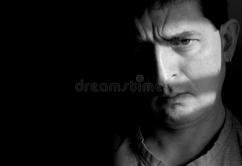 Doubtful. Black and white photo of a man with a furrowed brow and a doubtful look on his face. Half of the man's face is hidden in shadow, while the other half stock image Doubtful. Black and white photo of a man with a furrowed brow and a doubtful look on his face. Half of the man's face is hidden in shadow, while the other half stock image