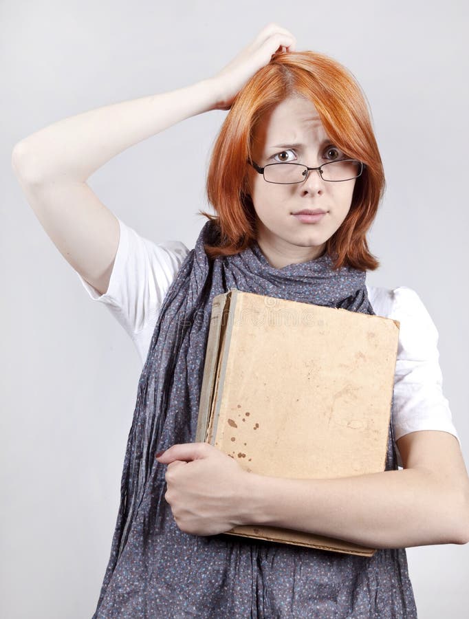 Doubting fashion girl in glasses with old book