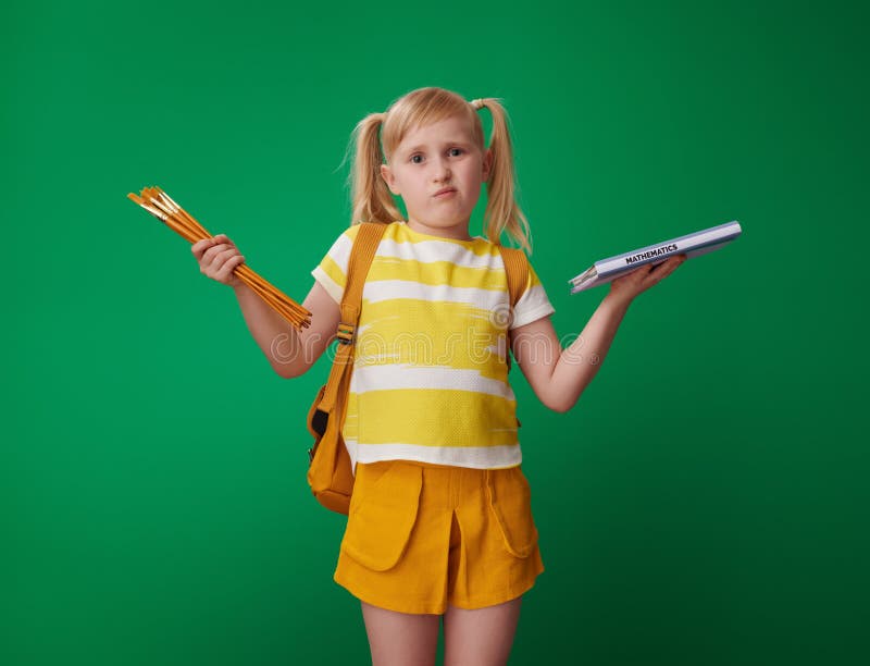 School girl choosing between sciences and art isolated on green royalty free stock photography School girl choosing between sciences and art isolated on green royalty free stock photography