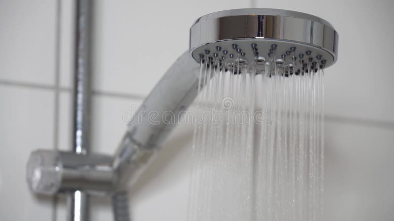 Douche avec pomme de douche moderne et l'eau courante dans la salle de bain banque de vidéos