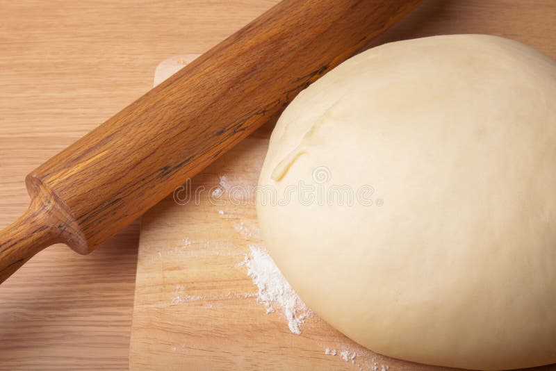 Dough on a Board and Rolling Pin with Flour for Sprinkling Stock Image