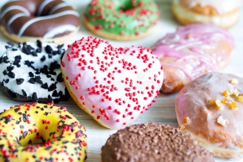 Doughnuts donuts various types of cakes with heart fat thursday Valentine`s Day concept still life. Doughnuts donuts various types of cakes with heart fat thursday Valentine`s Day concept still life