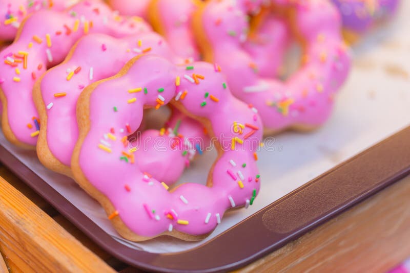 Doughnut ή βερνικωμένη η doughnut ζάχαρη που παγώνει το γλυκό ροζ ψεκάζει στοκ εικόνες Doughnut ή βερνικωμένη η doughnut ζάχαρη που παγώνει το γλυκό ροζ ψεκάζει στοκ εικόνες