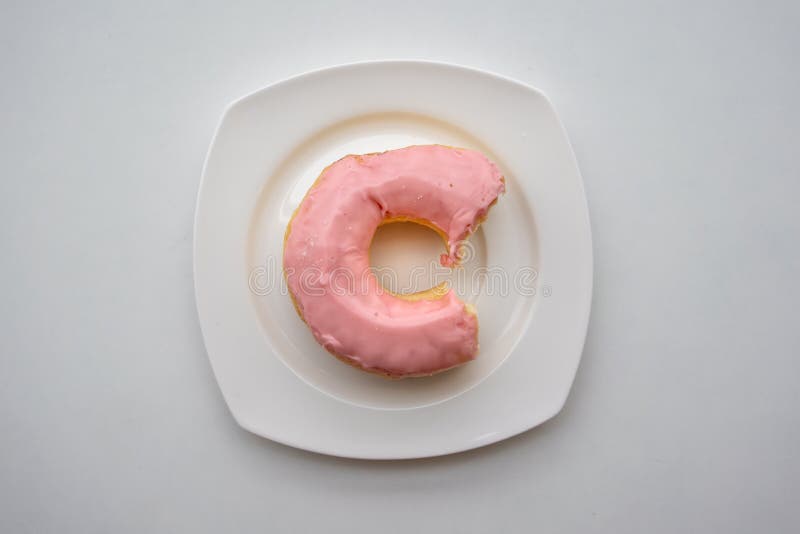 Doughnut δαγκωμάτων δαχτυλίδι με το λούστρο γεύσης φραουλών που παγώνει στο άσπρο π στοκ εικόνα με δικαίωμα ελεύθερης χρήσης Doughnut δαγκωμάτων δαχτυλίδι με το λούστρο γεύσης φραουλών που παγώνει στο άσπρο π στοκ εικόνα με δικαίωμα ελεύθερης χρήσης