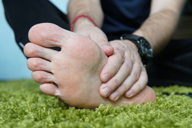 Douleur dans le pied Massage des pieds masculins pedicures pied cassé, un pied endolori, massant le talon photographie stock Douleur dans le pied Massage des pieds masculins pedicures pied cassé, un pied endolori, massant le talon photographie stock