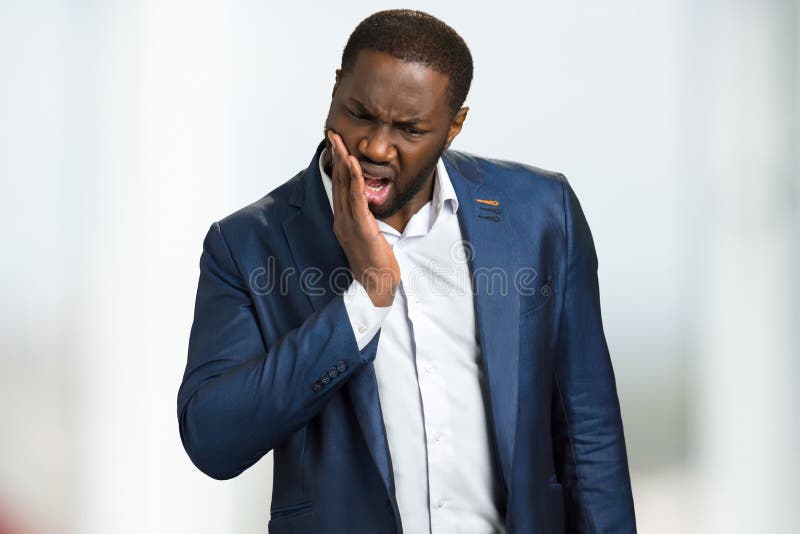 Douleur de dent de sentiment d'homme d'affaires photographie stock libre de droits Douleur de dent de sentiment d'homme d'affaires photographie stock libre de droits